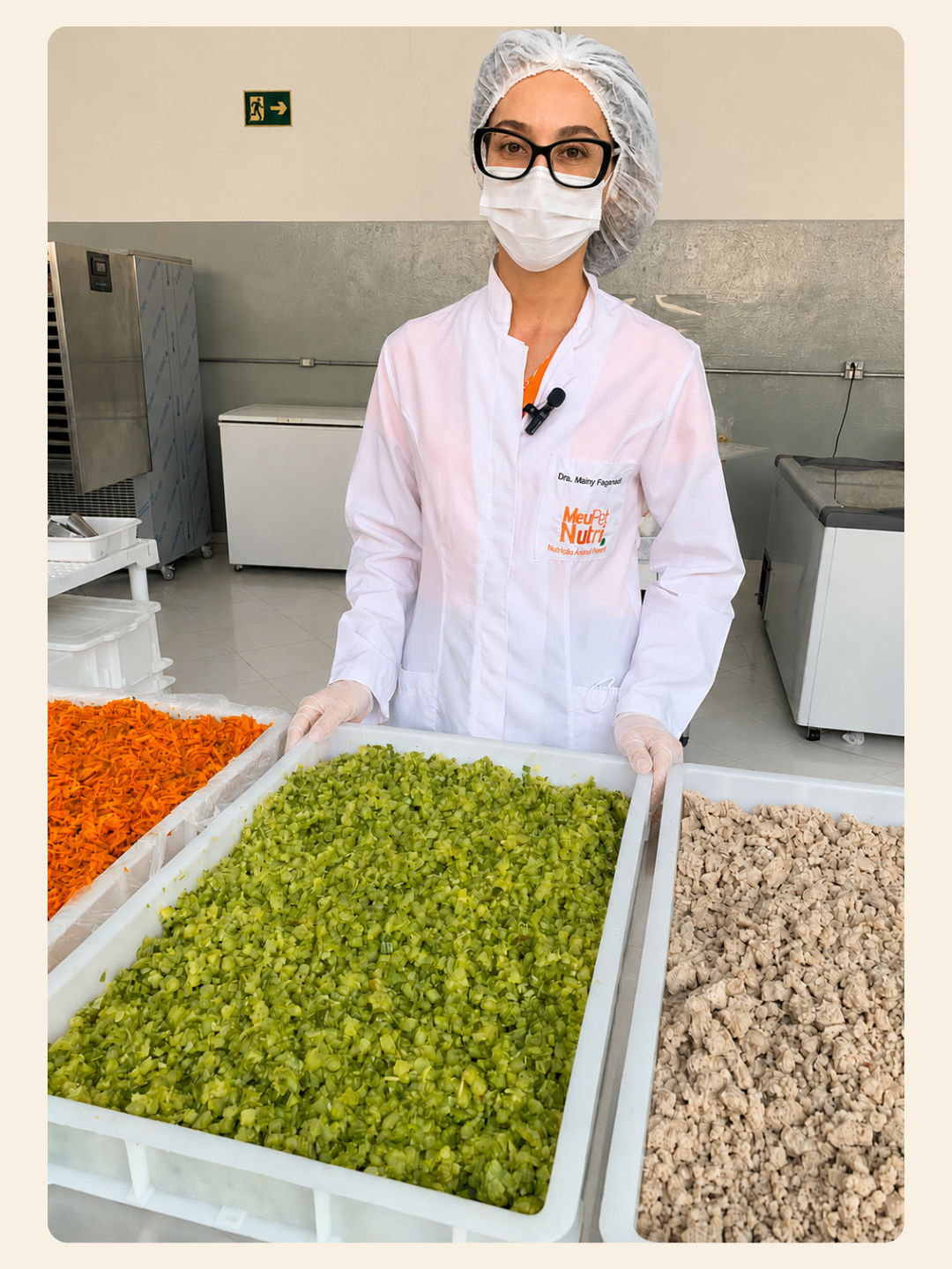 Médica-veterinária responsável técnica da Meu Pet Nutri na cozinha própria, com bandejas de vegetais e proteína higienizados